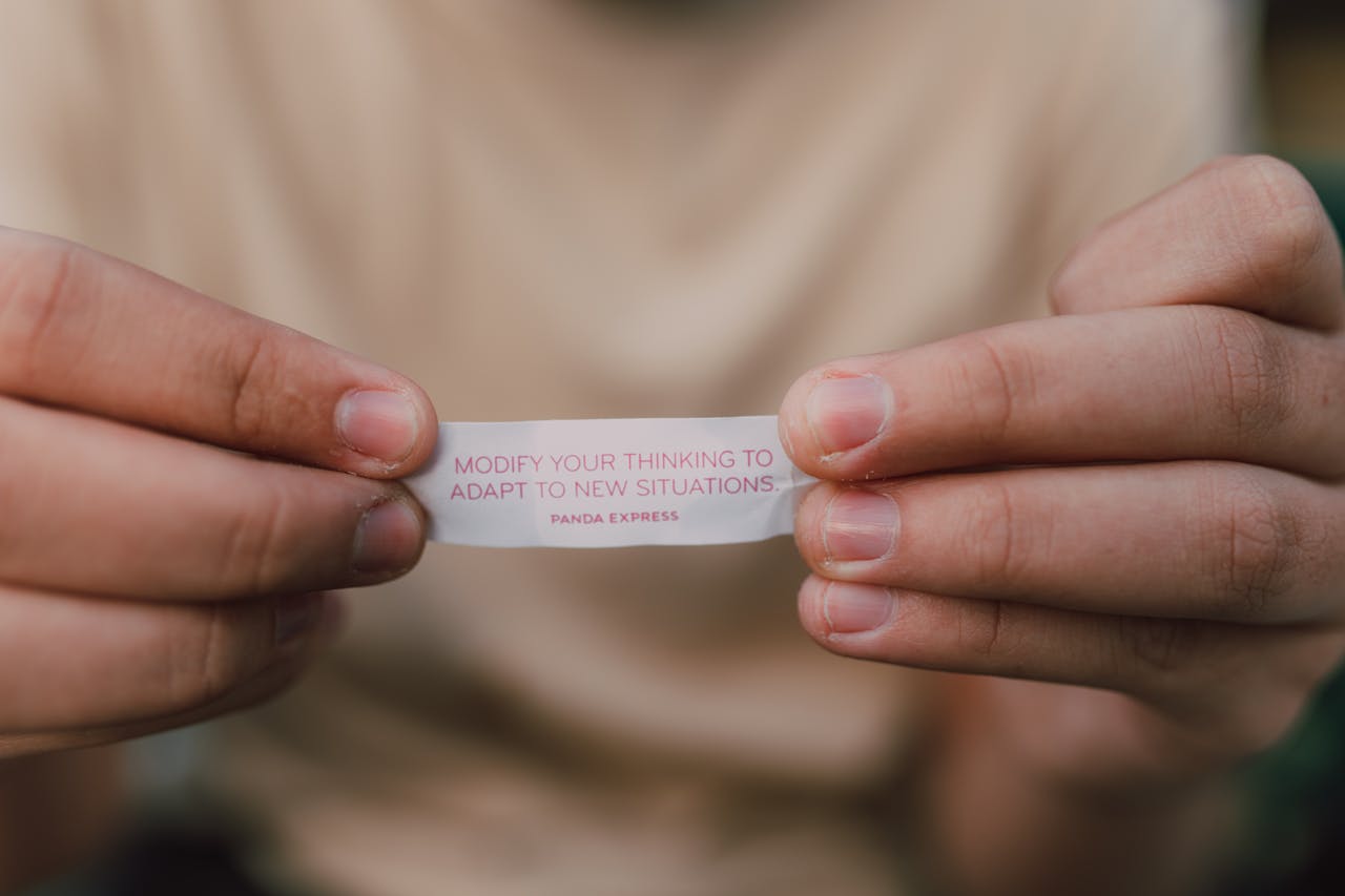 Home Close-up of hands holding a fortune cookie paper with insightful message